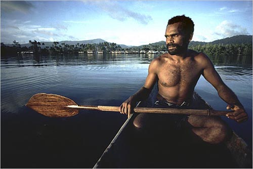 Fisherman in dugout canoe, Langalanga Lagoon, Malaita Island, Solomon Islands. copyright Michael McCoy