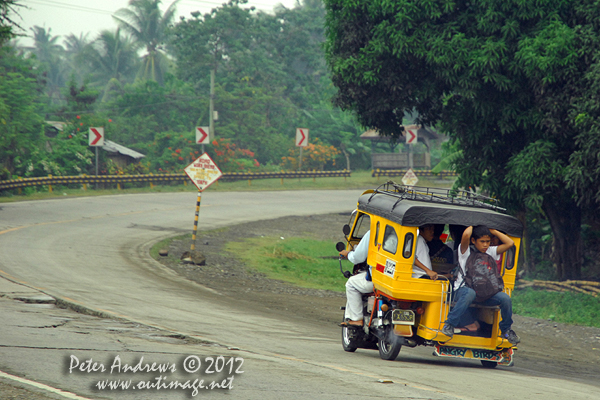 Off to school on the Angry Birds trike. Along the highway to Kidapawan City, Davao del Sur Province, Mindanao, Philippines. Photo copyright Peter Andrews, Outimage Australia.