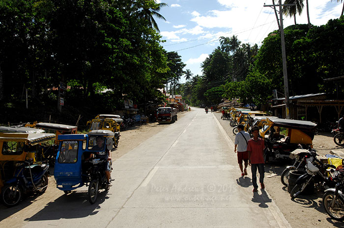 Motorcycle taxi trikes line Circumferencial Road waiting for fares, the main road near the Samal Island Ferry Terminal.