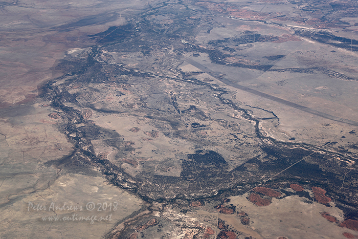Fence-lines and dirt tracks scar the landscape of the Channel Country in Outback Queensland near Aramac, where any water from flodding storms flows towards central South Australia. High altitude shots from a flight between Sydney Australia and Manila, Philippines.