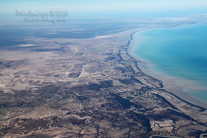 Looking across the tidal mudflats towards the Queensland outback town of Burketown with the Flinders River winding towards the Gulf of Carpentaria, near Normanton in outback Queensland. 17°35'44.4"S 140°44'31.6"E. High altitude shots from a flight between Sydney Australia and Manila, Philippines.