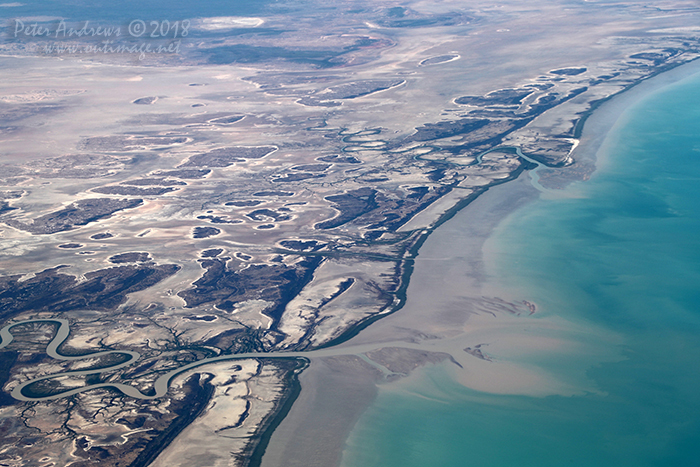 The Flinders River and Spring Creek wind their way through tidal mudflats depositing silt into the Gulf of Carpentaria, near Normanton in outback Queensland. 17°28'04.0"S 140°38'56.9"E. High altitude shots from a flight between Sydney Australia and Manila, Philippines.