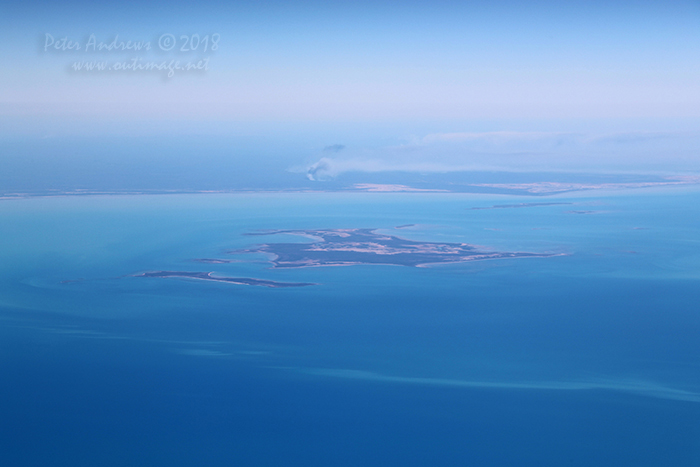 Looking towards the South Wellesley Islands in the Gulf of Carpentaria with bushfire burning on the mainland, near Burketown in outback Queensland. 17°17'10.1"S 140°32'02.8"E. High altitude shots from a flight between Sydney Australia and Manila, Philippines.