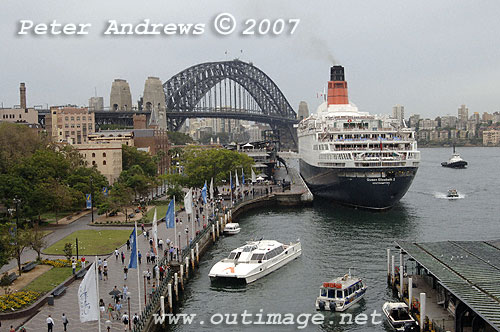 QE2 at Circular Quay with the Sydney Harbour Bridge in the background and The Rocks (locality) to the left.