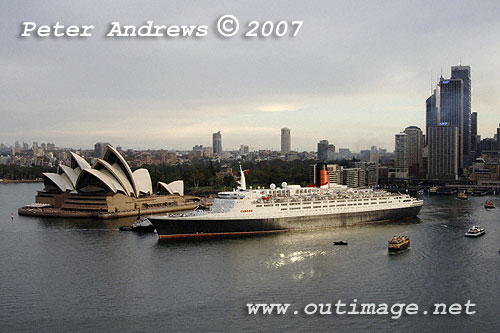 A shaft of sunlight reflects off the QE2 as it departs Circular Quay Sydney.