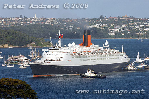 Queen Elizabeth II with assistance from tugs turns towards Circular Quay on Sydney Harbour.