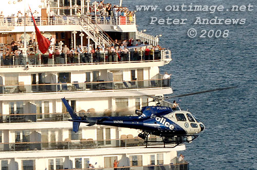 A Police helicopter sweeps past the stern of Queen Victoria on Sydney Harbour.