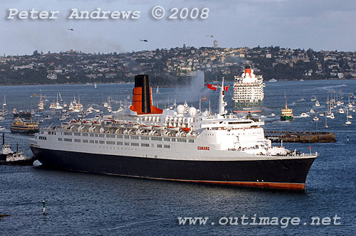 Queen Elizabeth II steaming to Circular Quay with Queen Victoria in the background leaving Sydney Harbour.