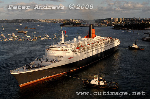 Queen Elizabeth II being positioned by tugs off the Sydney Opera House to go astern into Circular Quay.