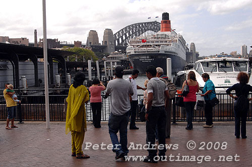 Visitors at Circular Quay, Sydney looking at the Queen Elizabeth 2 with the Sydney Harbour Bridge in the background.