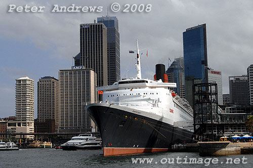 Queen Elizabeth II alongside at the Overseas Passenger Terminal, Circular Quay Sydney with the city skyline in the background.