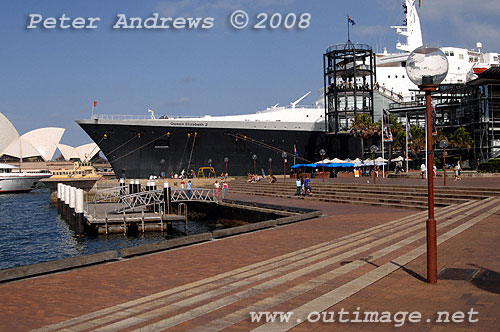 The bow of Queen Elizabeth II alongside at the Overseas Passenger Terminal, Circular Quay Sydney viewed from Campbells Cove with the Sydney Opera House in the background.