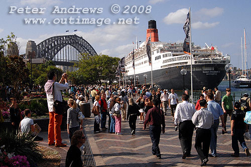 Queen Elizabeth 2 alongside at the Overseas Passenger Terminal, Circular Quay Sydney with visitors to the Quay in the foreground.