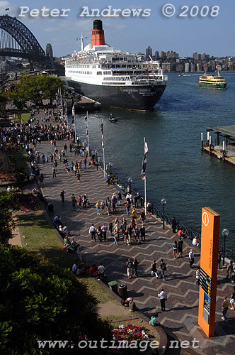 Queen Elizabeth 2 at the Overseas Passenger Terminal, Circular Quay Sydney with a Manly ferry approaching the Quay in the distance.