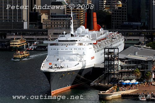 Queen Elizabeth 2 at Circular Quay Sydney with a Lady Class passenger ferry leaving the Quay.