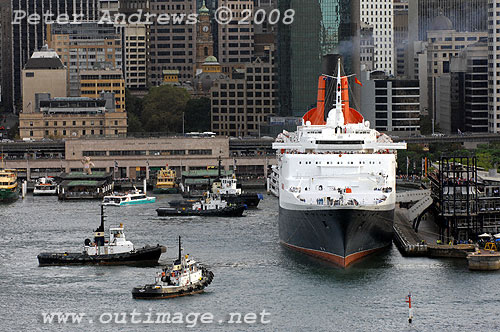 Four tugs standby Queen Elizabeth 2 in Circular Quay for her final Sydney departure.