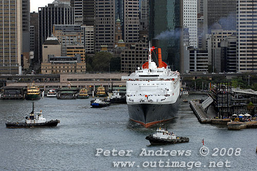 Four tugs assist Queen Elizabeth 2 in Circular Quay Sydney as the ship leaves the wharf of the Overseas Passenger Terminal.