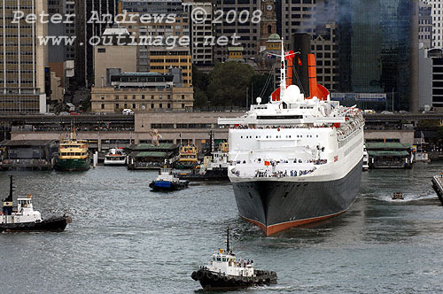 Clear of the wharf, Queen Elizabeth 2 in Circular Quay Sydney with assisting tugs leaves the Overseas Passenger Terminal.