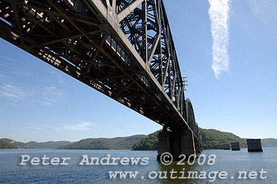 Passing under the Hawkesbury River Railway Bridge, the pylons to the right reveal the location of the original bridge constructed between 1887 and 1889. The current bridge replaced the old bridge in 1946 as a result of the old bridge becoming unsafe.