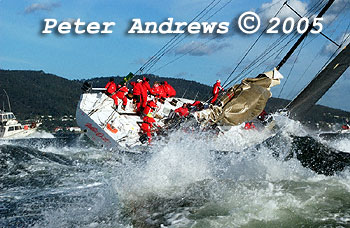 This picture shows Wild Oats eleven powering up the Derwent River off Taroona near Hobart at the end of the 2005 race with the mainsail lashed down to the boom, but making great progress with just a headsail. The foreground is awash with white water churned up from the many powerboats chasing Wild Oats up the river to the finishing line. 