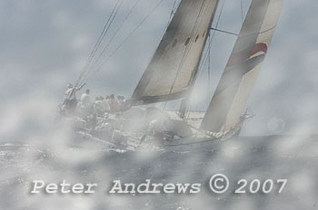 Looking at the back of Matt Allen's Ichi Ban sailing away, just outside the heads after the start of the 2007 Audi Sydney Southport Yacht Race. The image of the boat is blured by a mass of water spray in front of the camera that is out of focus, with an almost hidden sharp image of the boat in the background.