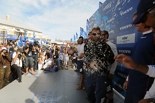 Navigator Jules Salter sprays champagne over his fellow crew members on stage. Photo copyright Dave Kneale - Volvo Ocean Race. 