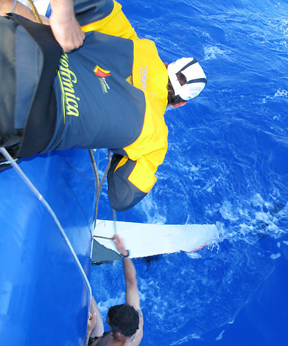 Iker Martinez leans over to help fellow spaniard Pepe Ribes from Spain checking the broken daggerboard onboard Telefonica Blue. Photo copyright Gabriele Olivo / Telefonica Blue / Volvo Ocean Race.