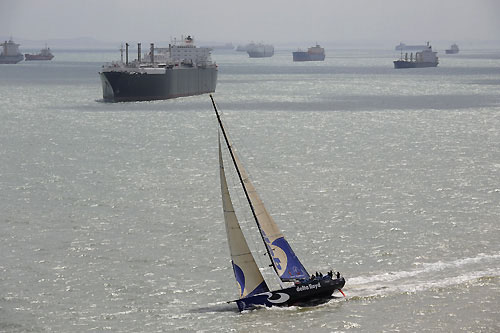 Delta Lloyd, skippered by Roberto Bermudez (ESP) at the start of leg 4 of the Volvo Ocean Race, from Singapore to Qingdao, China. In the background are some of the vast number of ships anchored outside this busy global maritime crossroad. Photo copyright Rick Tomlinson / Volvo Ocean Race.