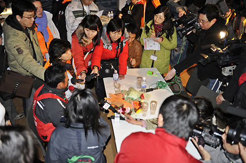 Media crew member Guo Chuan (CHI) is interviewed by the local Chinese media after Green Dragon, skippered by Ian Walker (GBR) finishes 4th on leg 4 of the Volvo Ocean Race in Qingdao, China. Photo copyright Rick Tomlinson / Volvo Ocean Race.