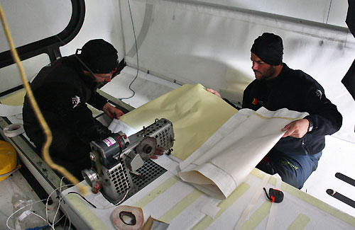 Jordi Calafat and Pablo Arrarte prepare a patch for the mainsail, earlier on leg 5 of the Volvo Ocean Race, from Qingdao to Rio de Janeiro. Photo copyright Gabriele Olivo / Telefonica Blue / Volvo Ocean Race.