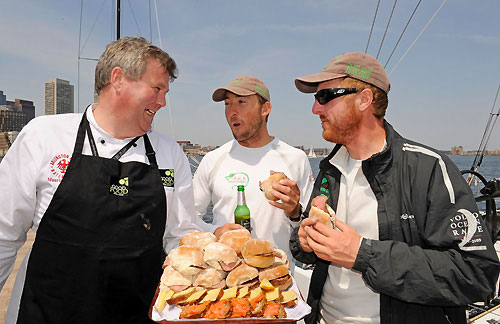 On the dock in Boston, a representative from Good Food Ireland serves Andrew McLean (NZL) centre and James Carroll (IRE) right from Green Dragon, butties and smoked salmon that were produced in Ireland. Photo copyright Rick Tomlinson / Volvo Ocean Race.