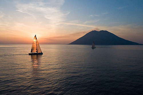 Andres Soriano's Alegre and Roger Sturgeon's Rosebud / Team DYT making slow progress towards Stromboli at dusk, during the Rolex Middle Sea Race 2008. Photo copyright ROLEX and Kurt Arrigo.
