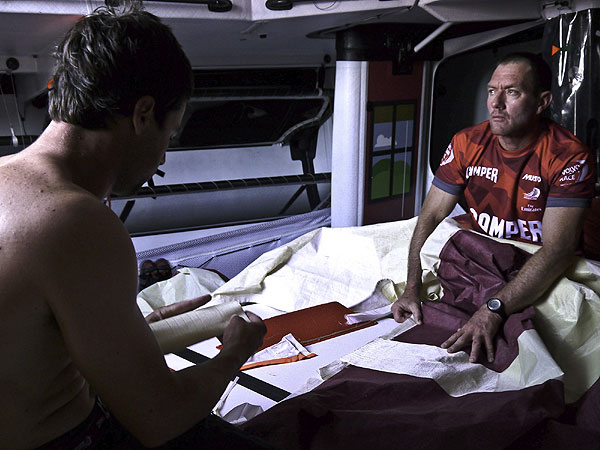 Tony Rae and Daryl Wislang repair a torn sail onboard CAMPER with Emirates Team New Zealand during Leg 1 of the Volvo Ocean Race 2011-12, from Alicante, Spain to Cape Town, South Africa. Photo Hamish Hooper / CAMPER ETNZ / Volvo Ocean Race.