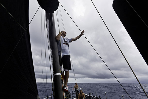 Navigator Tom Addis stands on the boom for a better view of the weather after exiting the Doldrums. PUMA Ocean Racing powered by BERG during leg 1 of the Volvo Ocean Race 2011-12, from Alicante, Spain to Cape Town, South Africa. Photo Amory Ross / PUMA Ocean Racing / Volvo Ocean Race.